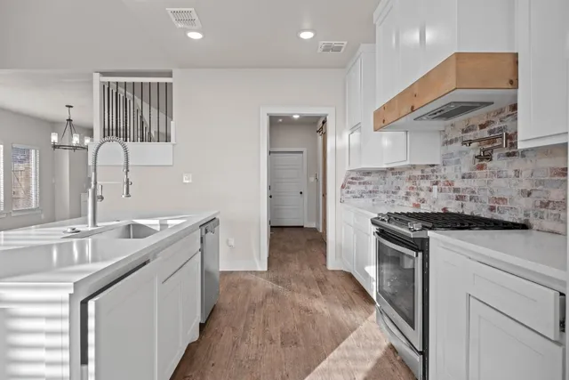 a kitchen with stainless steel appliances granite countertop a sink stove and refrigerator