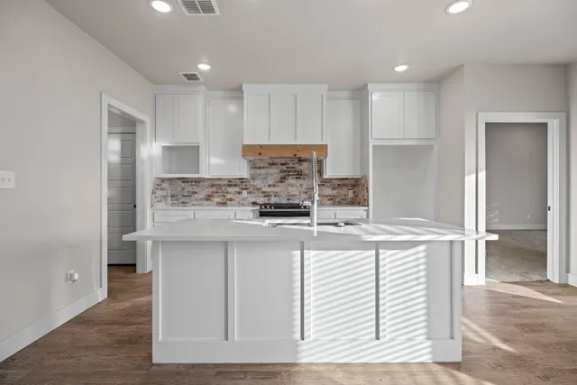 a kitchen with kitchen island cabinets and refrigerator