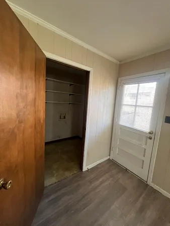 an empty room with wooden door and window