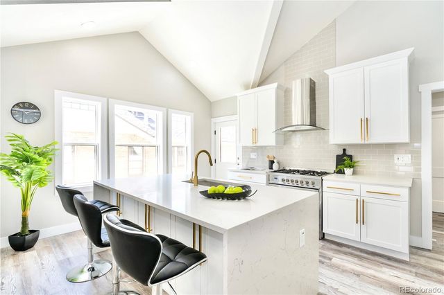 a kitchen with a stove a white cabinets a dining table and chairs