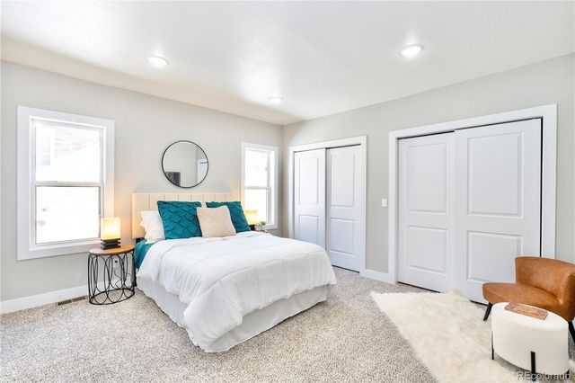 a bedroom with a bed chair and window