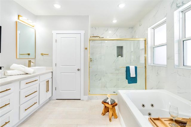 a bathroom with a tub a sink a mirror and a shower