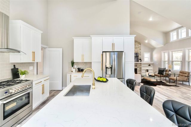 a large white kitchen with stainless steel appliances