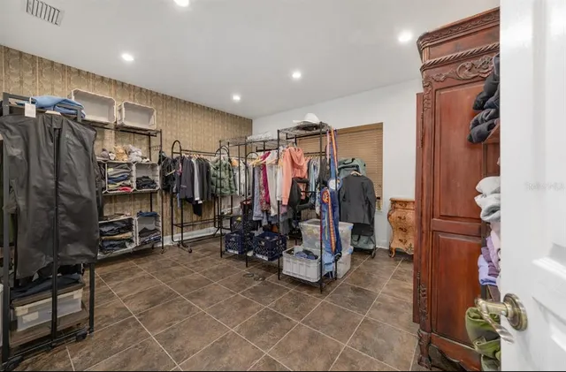 a view of walk in closet with clothes and shoes