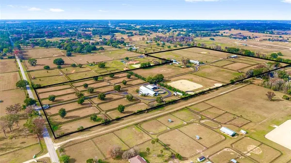 a view of a big house with a big yard and large trees