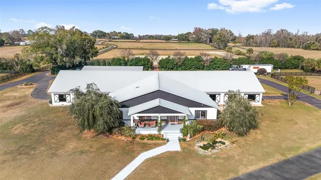 a view of an empty room with chandelier fan