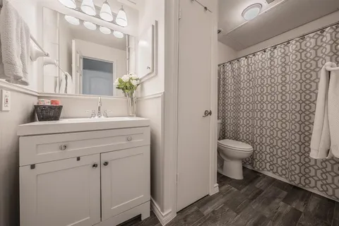a bathroom with a toilet sink and mirror