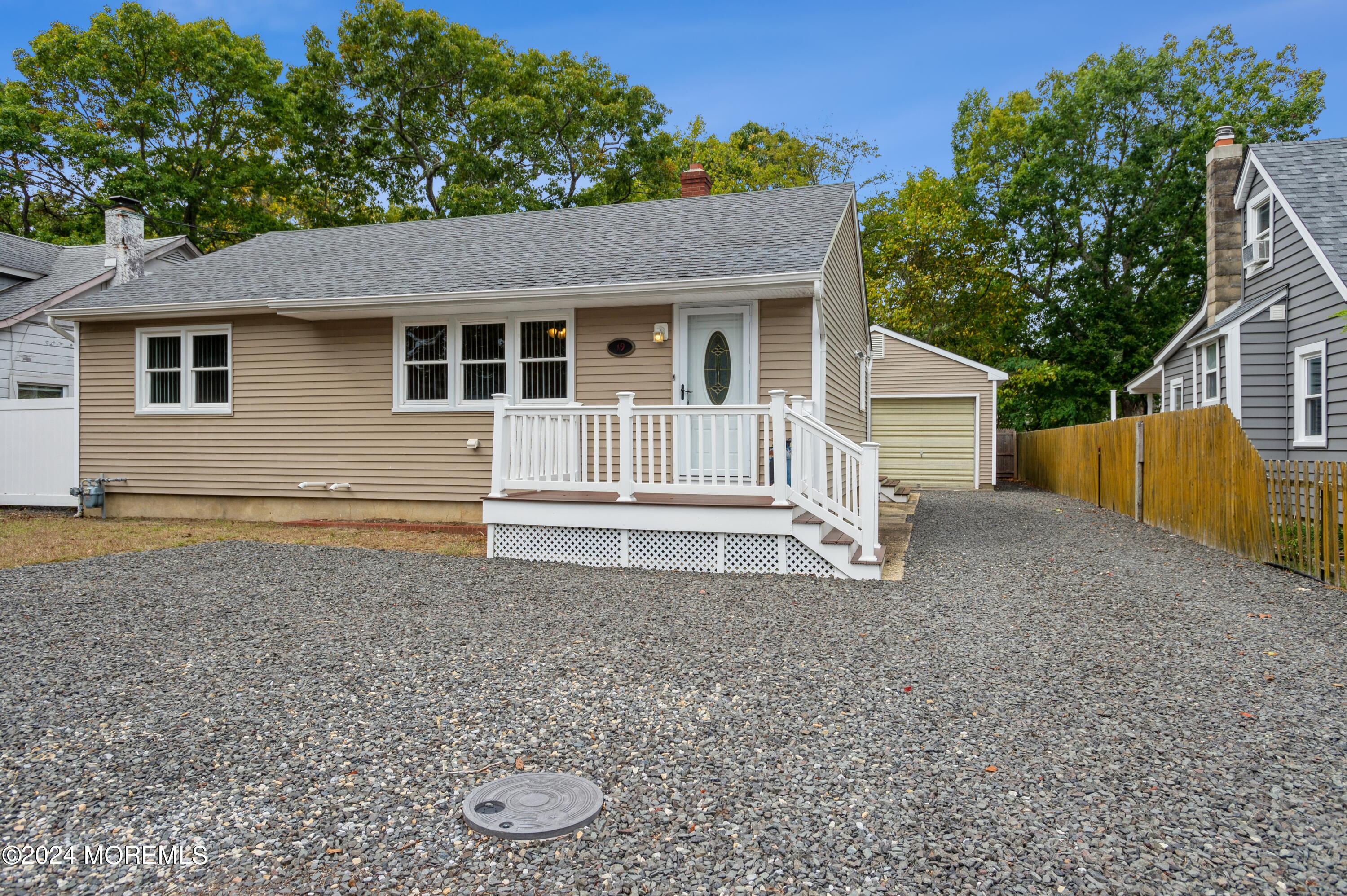 19 Holly Road Brick, NJ 08723 - Photo 16 of 16 a house with white wall and a large tree