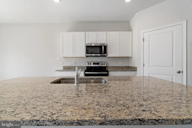 a kitchen with granite countertop a stove and a sink