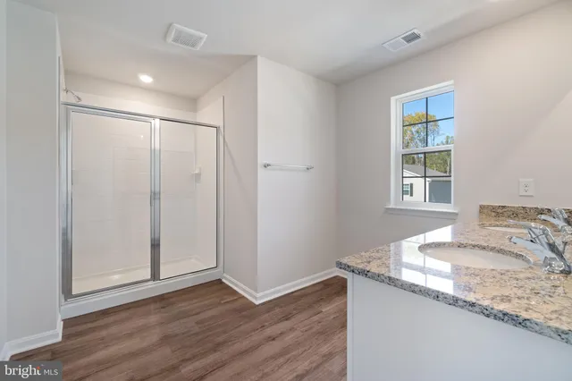 a bathroom with a granite countertop sink and a window