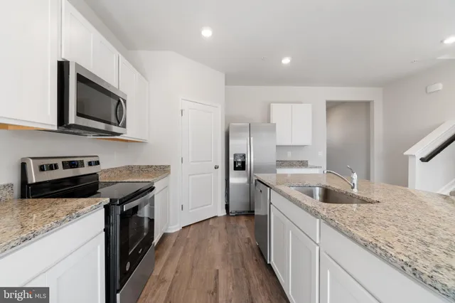 a kitchen with granite countertop a sink and steel appliances