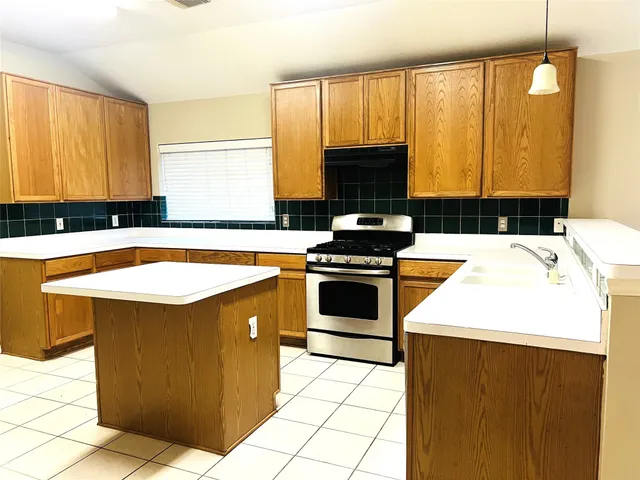 a kitchen with stainless steel appliances a stove a sink and a microwave