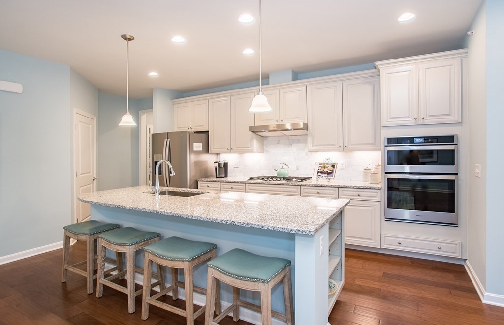 52 Sienna, Unit 47 Upton, MA 01568 - Photo 2 of 17 a kitchen with stainless steel appliances granite countertop a table chairs sink and cabinets