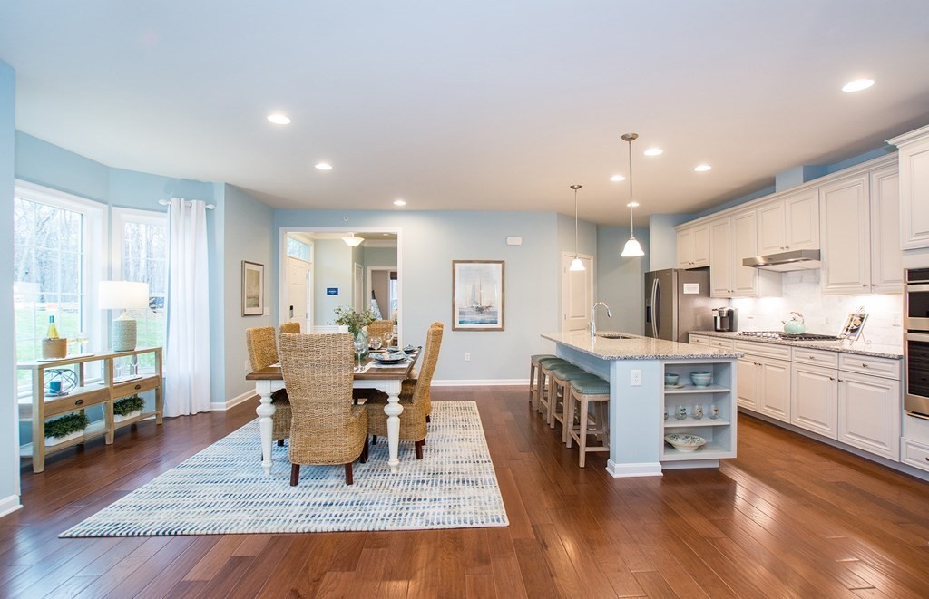 52 Sienna, Unit 47 Upton, MA 01568 - Photo 6 of 17 a living room with stainless steel appliances granite countertop furniture wooden floor and a kitchen view