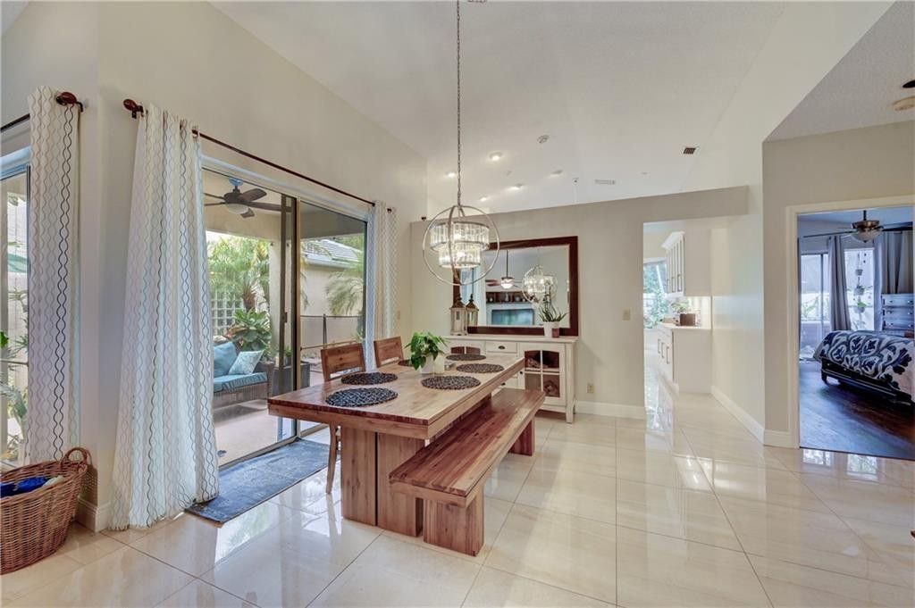 8171 Hampton Wood Drive Boca Raton, FL 33433 - Photo 8 of 56 a living room with furniture a large window and a chandelier