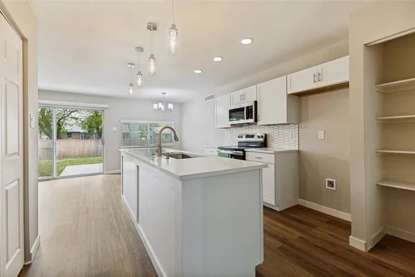 a kitchen with kitchen island a sink stainless steel appliances and cabinets