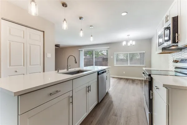 a kitchen with stainless steel appliances granite countertop a sink stove and wooden floor