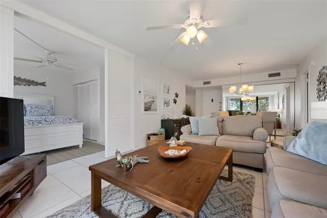 a living room with furniture a fireplace and a chandelier