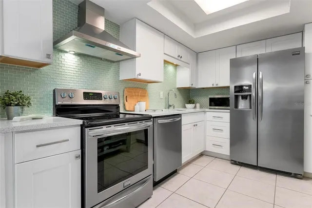 a kitchen with stainless steel appliances granite countertop a stove a refrigerator and a sink