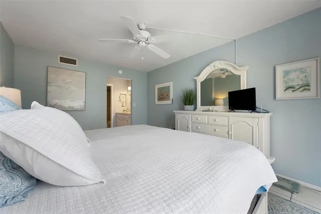 a bedroom with a large bed and a flat screen tv