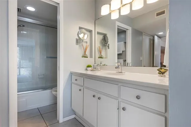 a bathroom with a double vanity sink mirror and bathtub