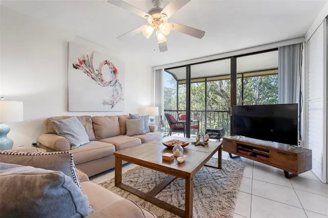 a living room with furniture a flat screen tv and a large window