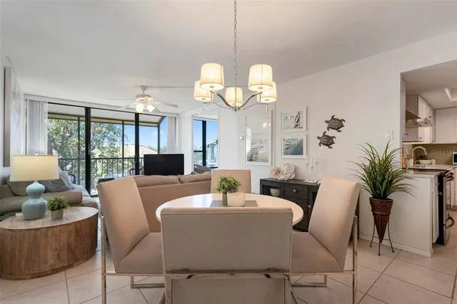 a view of a dining room with furniture a chandelier and large windows