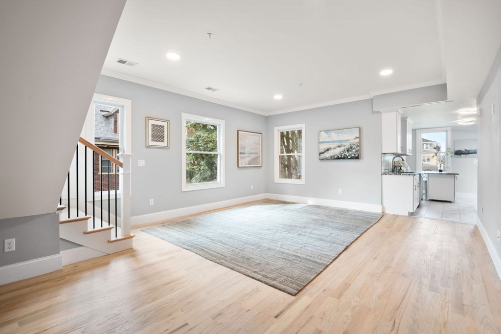 a view of empty room with wooden floor and windows