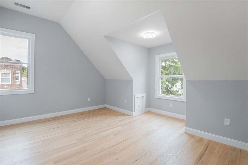 7 Waumbeck Street, Unit 2 Boston, MA 02121 - Photo 11 of 18 an empty room with wooden floor and windows