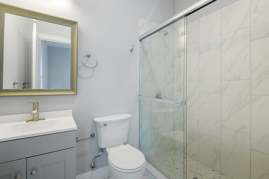7 Waumbeck Street, Unit 2 Boston, MA 02121 - Photo 12 of 18 a bathroom with a toilet a sink and shower