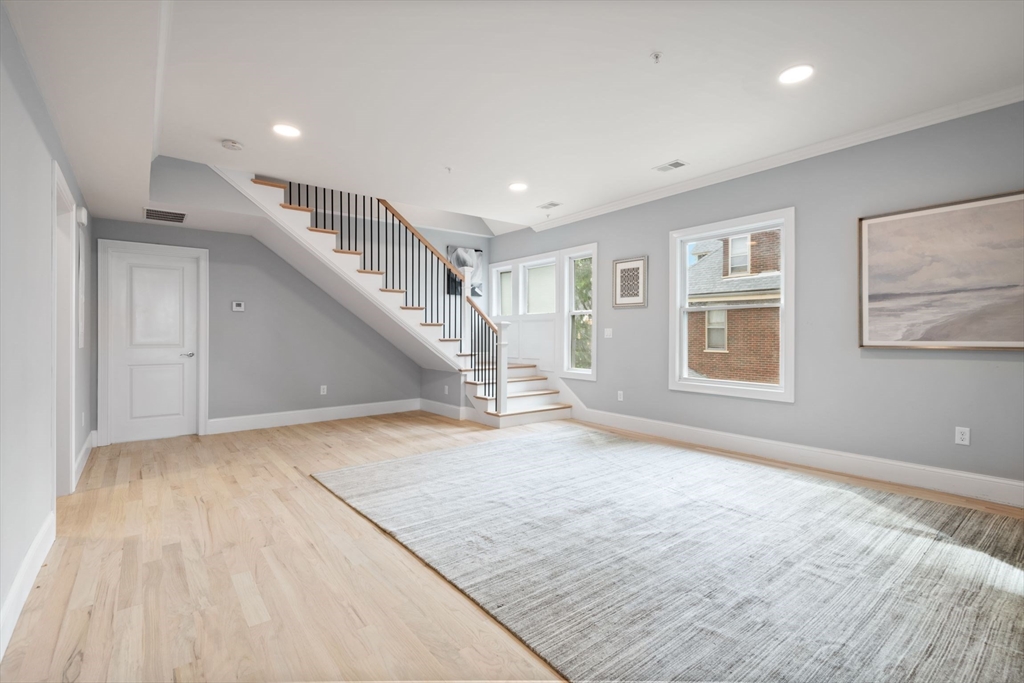 7 Waumbeck Street, Unit 2 Boston, MA 02121 - Photo 2 of 18 a view of an empty room with wooden floor and stairs