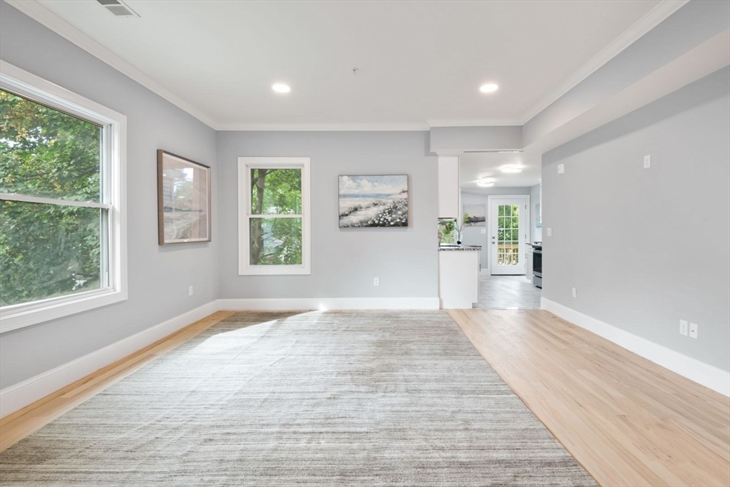 7 Waumbeck Street, Unit 2 Boston, MA 02121 - Photo 3 of 18 a view of a big room with windows and wooden floor