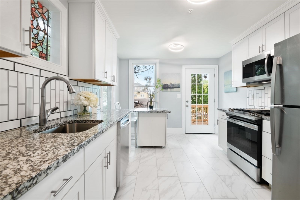 7 Waumbeck Street, Unit 2 Boston, MA 02121 - Photo 4 of 18 a kitchen with granite countertop a sink stove and cabinets