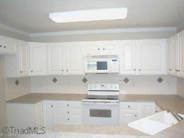 1040 Woodbury Road King, NC 27021 - Photo 6 of 9 Other. Kitchen w/white appliances (flat-top range/oven, built-in microwave & dishwasher. Breakfast bar plus breakfast nook area, plus formal dining area. Pantry & laundry area in closet at breakfast area.
