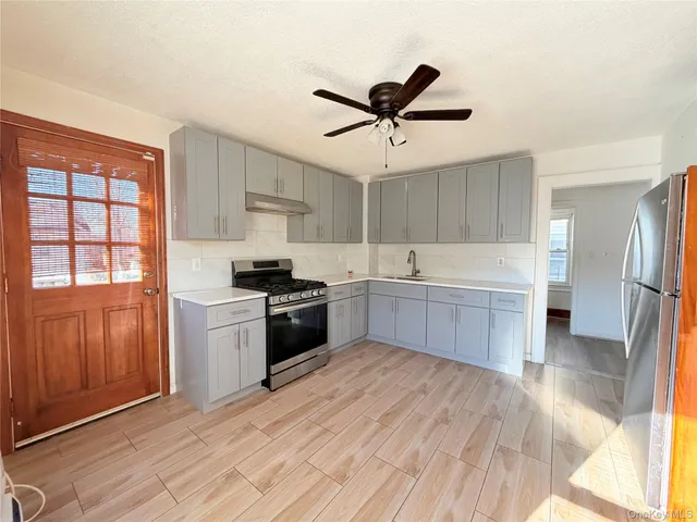 a kitchen with a refrigerator sink and cabinets