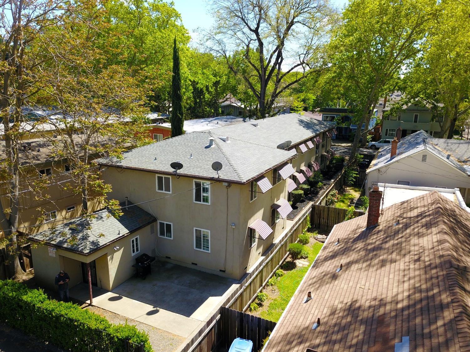 an aerial view of a house with swimming pool and large trees