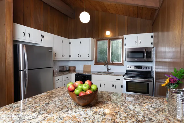 a kitchen with granite countertop a refrigerator and a stove