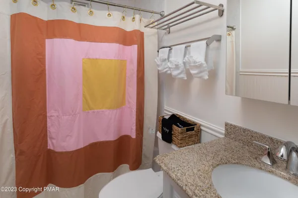 a bathroom with a granite countertop toilet sink and mirror