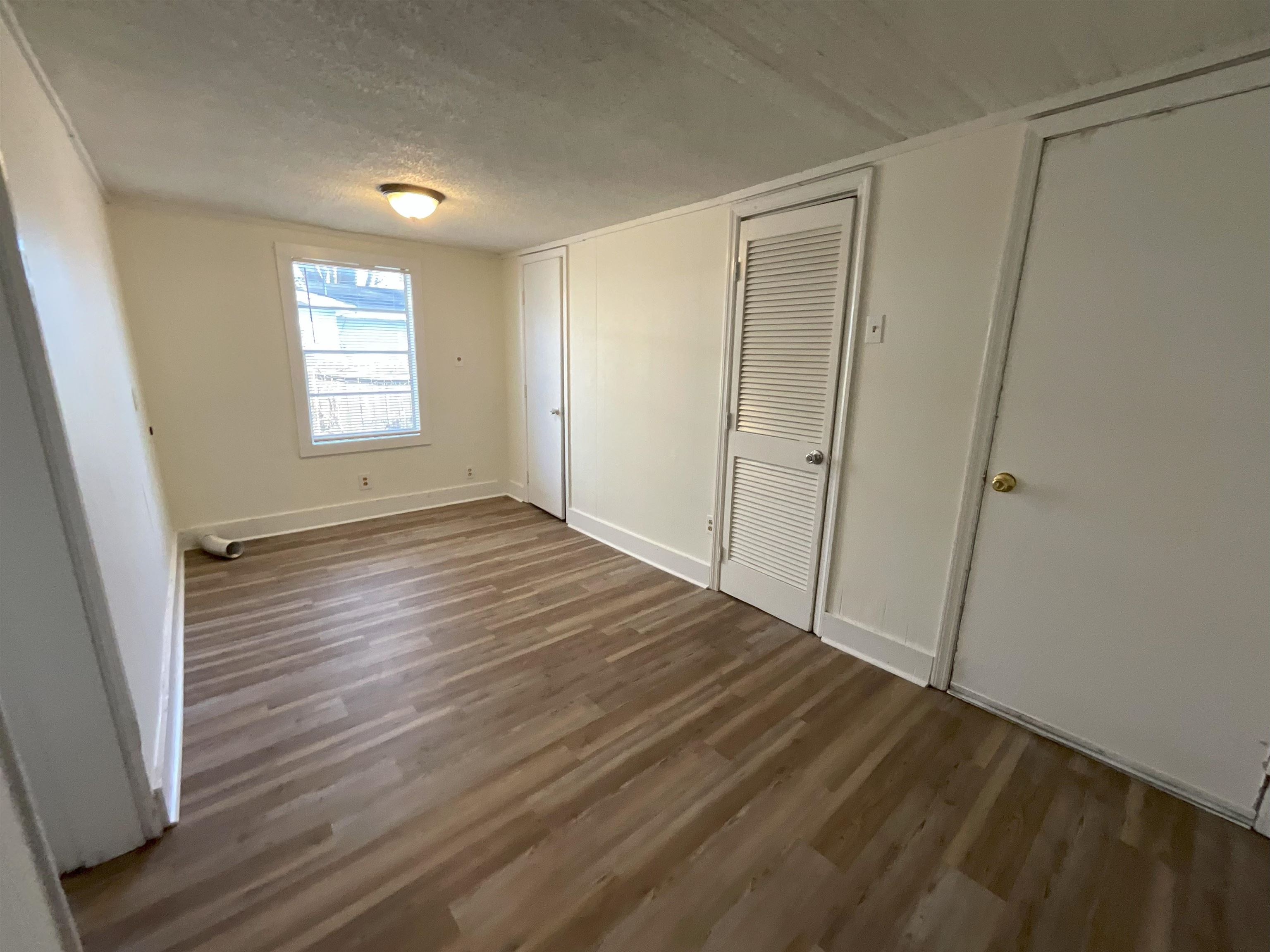 736 North Watkins Street Memphis, TN 38107 - Photo 6 of 14 an empty room with wooden floor and windows
