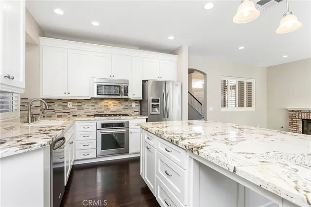 a kitchen with granite countertop cabinets stainless steel appliances and a counter top space