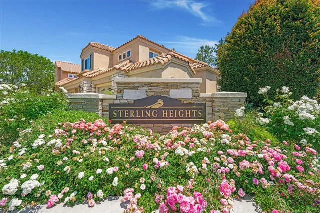 a front view of a house with a yard and fountain in middle of the road