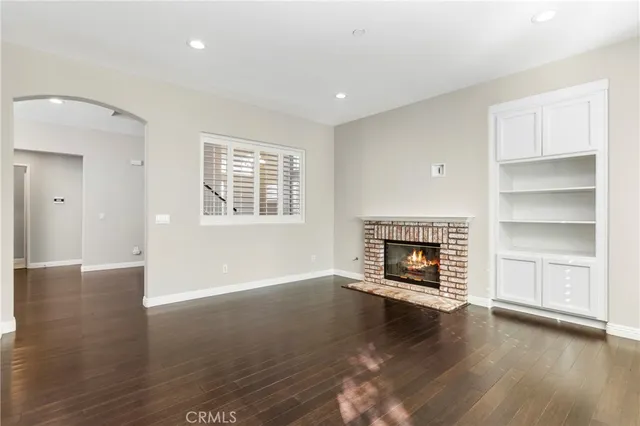 a view of an empty room with a fireplace and a window