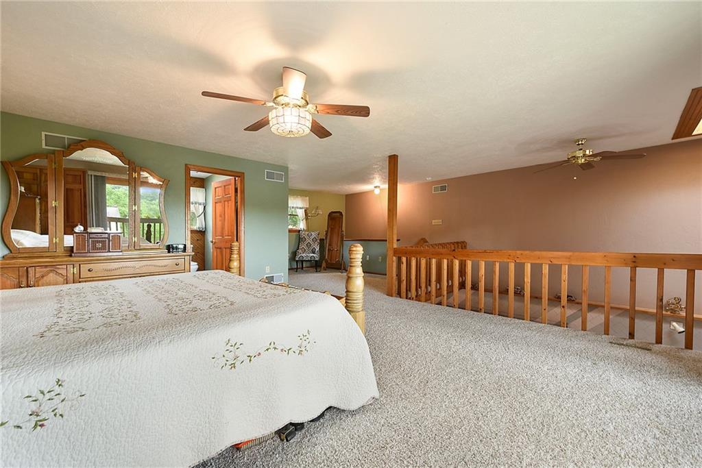 38 Manor Road Donora, PA 15033 - Photo 9 of 25 a spacious bedroom with a bed a chandelier and a large window