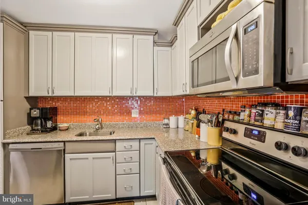 a kitchen with stainless steel appliances granite countertop a stove and a sink
