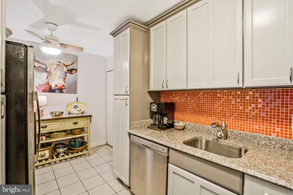 a kitchen with white cabinets and white appliances