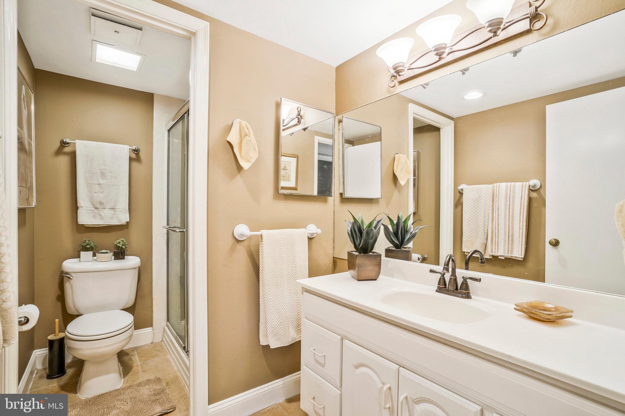 6101 Edsall Road, Unit 302 Alexandria, VA 22304 - Photo 32 of 59 a bathroom with a granite countertop sink mirror vanity and toilet