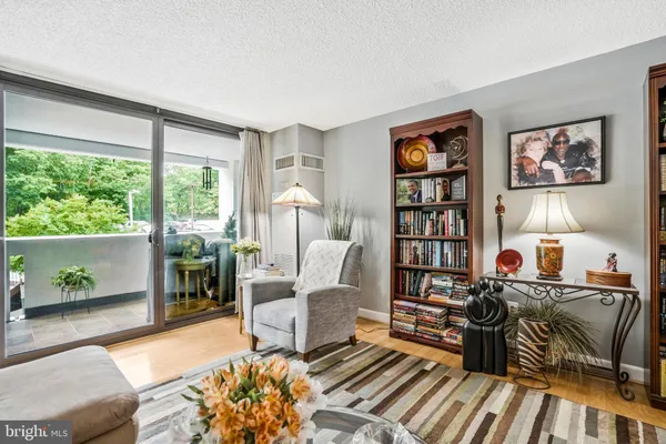 a living room with furniture a bookshelf and a large window
