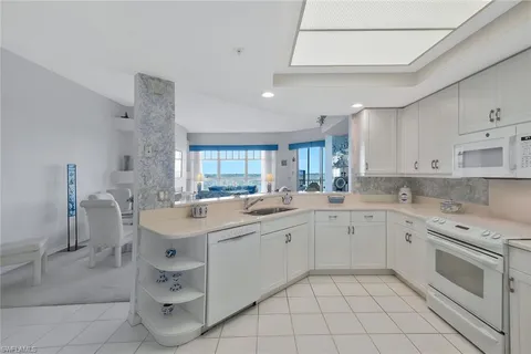 a view of a kitchen counter space with a sink and living room view