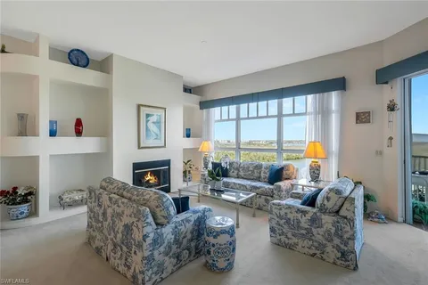 a living room with furniture a fireplace and a large window