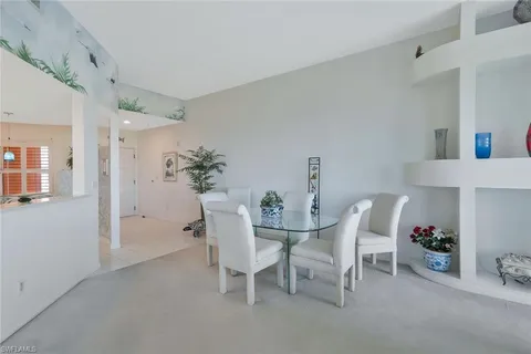 a dining room with furniture and potted plants